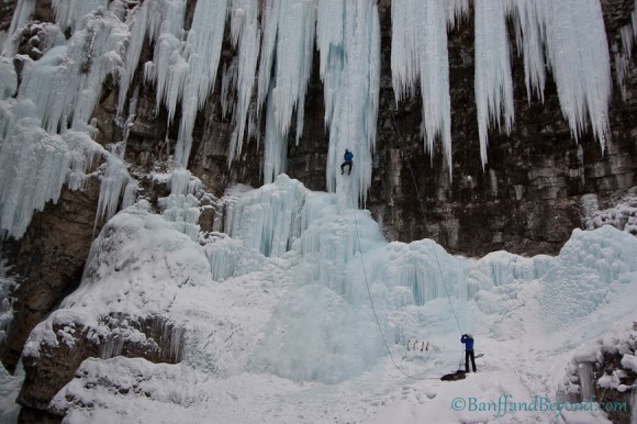 ice climbers on frozen upper falls in johnston canyon