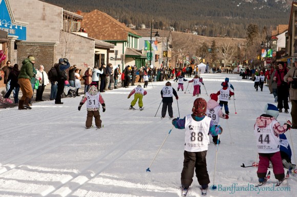 group-kids-racing-cross-country-nordic-skiing-main-street-downtown-canmore-winter-carnival