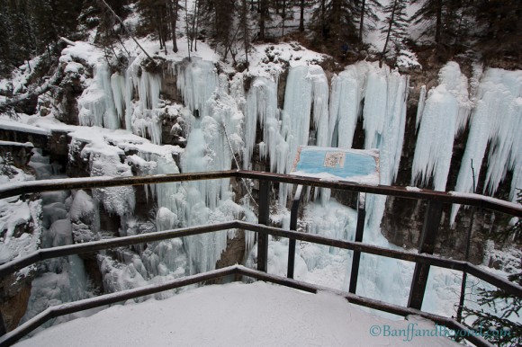 view from steel platform looking at frozen upper johnston canyon falls