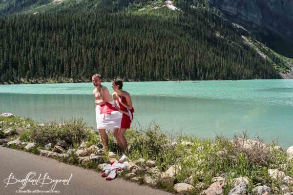 couple stands wrapped in canada flag after lake louise polar bear dip