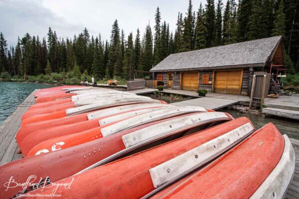 row of red canoes in front of fairmont chateau lake louise boathouse