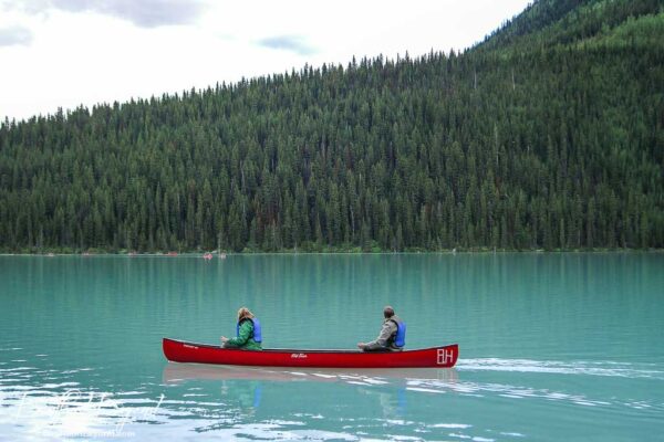 single canoe on turquoise waters of lake louise