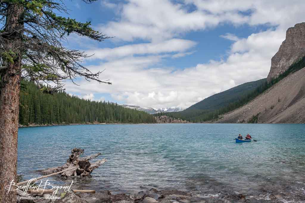 people paddling a canoe near the back of moraine lake