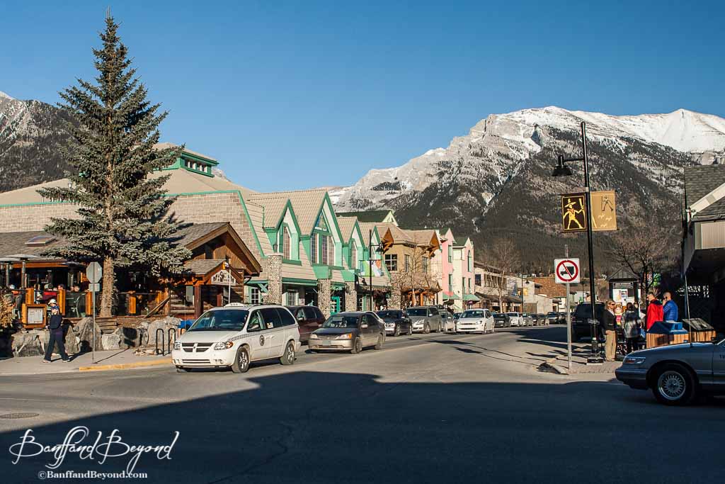 the main street in downtown canmore looking at shops and the mountains