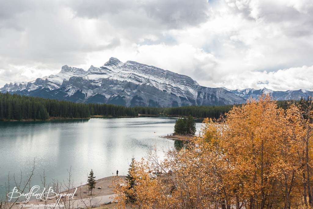 two jack lake with mountains in the background and yellow leaves on trees